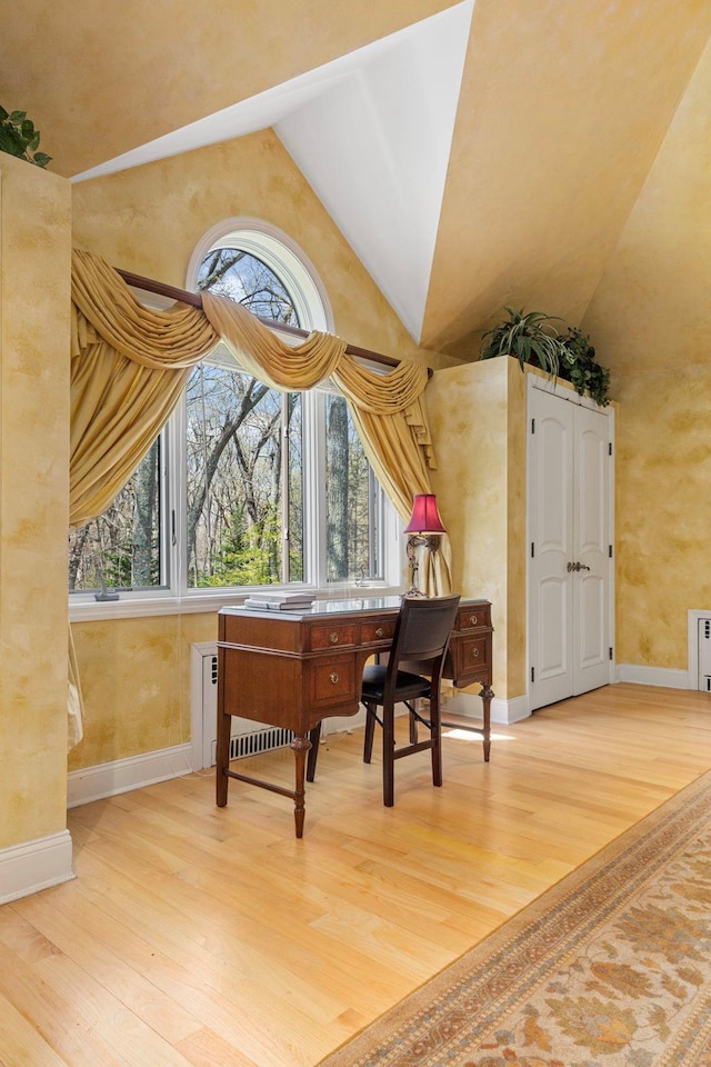 sitting room with baseboards, wood finished floors, and a healthy amount of sunlight