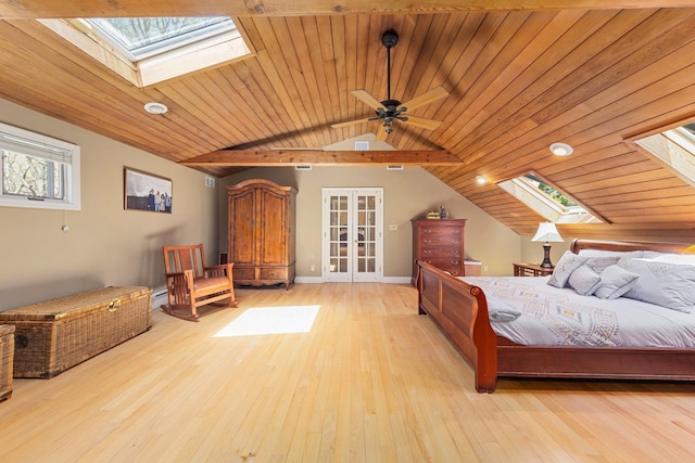 bedroom featuring hardwood / wood-style floors, vaulted ceiling with skylight, french doors, and wood ceiling