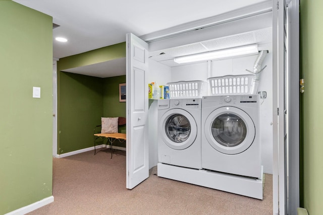 washroom featuring separate washer and dryer, carpet flooring, laundry area, and baseboards