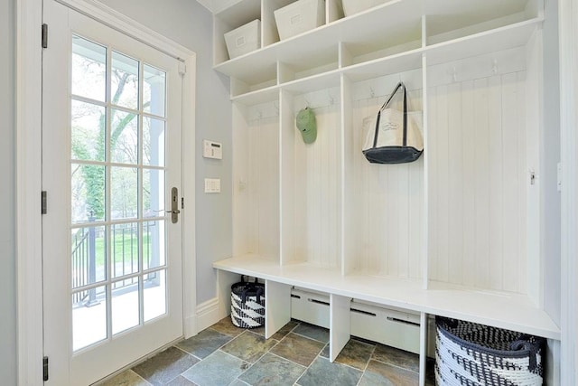 mudroom featuring baseboards and stone finish flooring