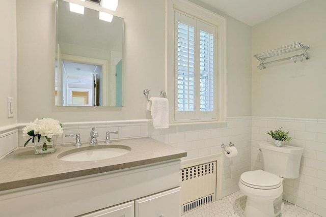 bathroom with radiator heating unit, tile patterned flooring, toilet, and a healthy amount of sunlight