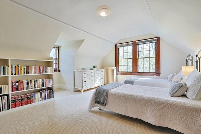 carpeted bedroom with baseboards, radiator heating unit, and vaulted ceiling