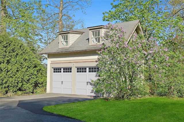 view of front of house with roof with shingles, a garage, a front yard, and aphalt driveway