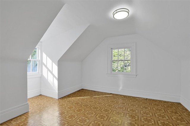 additional living space with baseboards and lofted ceiling