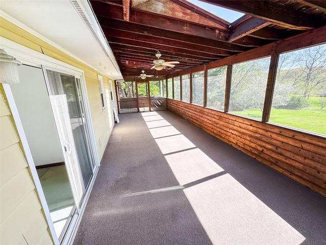 unfurnished sunroom with a ceiling fan and a skylight