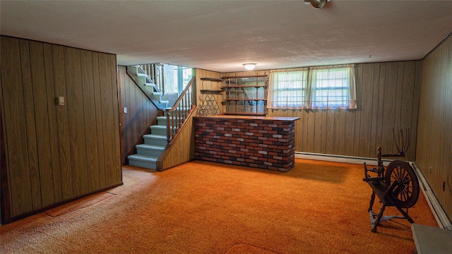 basement with wooden walls, baseboard heating, plenty of natural light, and stairs