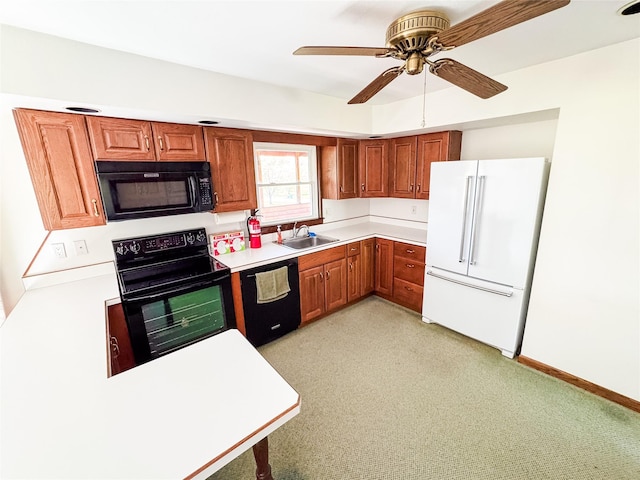 kitchen featuring a sink, light countertops, brown cabinetry, a ceiling fan, and black appliances