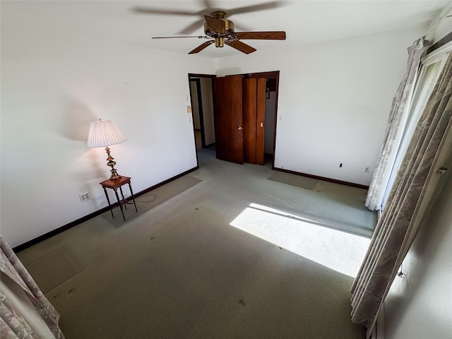 unfurnished bedroom featuring carpet floors, baseboards, and ceiling fan