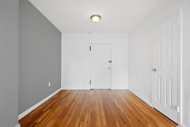 spare room with hardwood / wood-style floors and baseboards