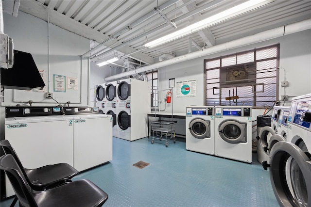 community laundry room featuring tile patterned floors, stacked washer / drying machine, and washer and clothes dryer