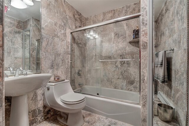 158-35 91st St, Howard Beach, NY 11414 - bathroom featuring toilet, tile walls, combined bath / shower with glass door, and a sink