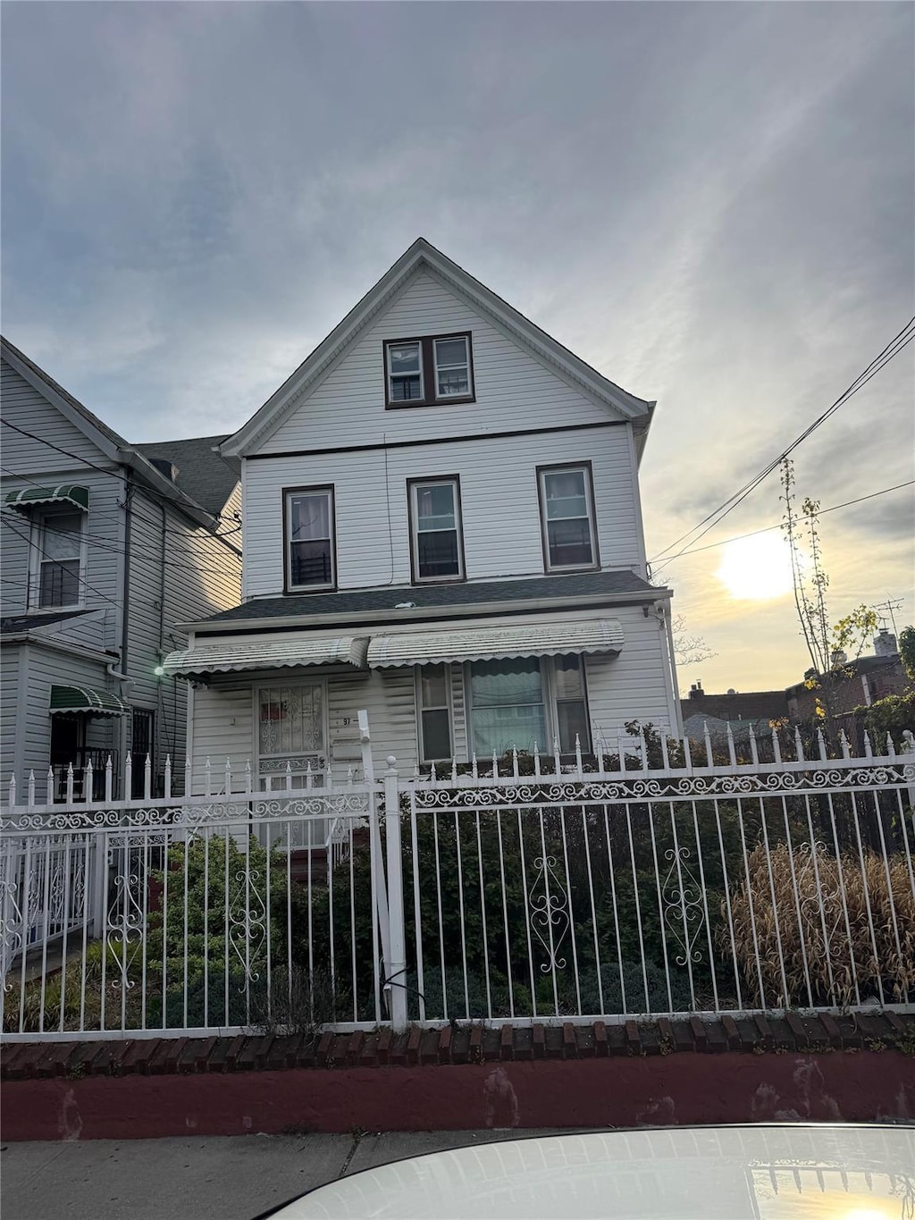 97-39 110th St, Richmond Hill, NY 11419 - american foursquare style home featuring covered porch and a fenced front yard