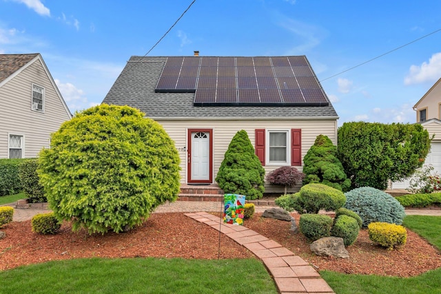 102 Spruce Ln, Valley Stream, NY 11581 - view of front of home featuring solar panels, a shingled roof, and entry steps