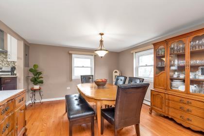 102 Spruce Ln, Valley Stream, NY 11581 - dining area with light wood finished floors, baseboard heating, and baseboards