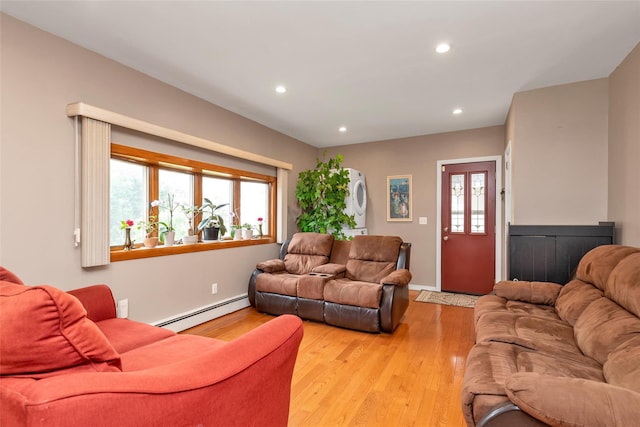102 Spruce Ln, Valley Stream, NY 11581 - living room with estacked washer and dryer, baseboard heating, recessed lighting, light wood-type flooring, and baseboards