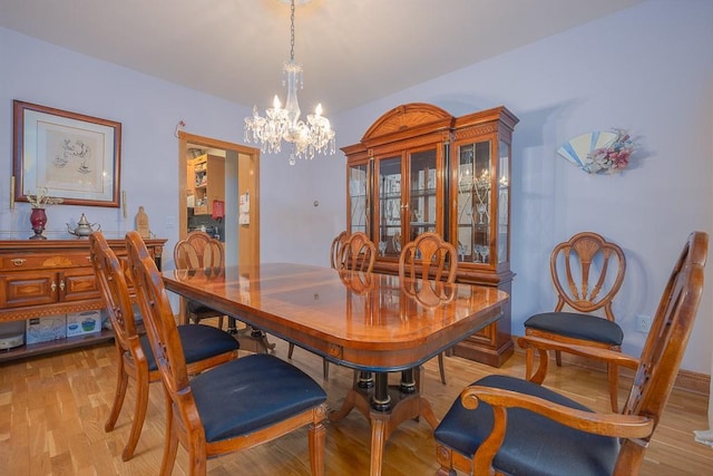dining area featuring an inviting chandelier and light wood-style flooring