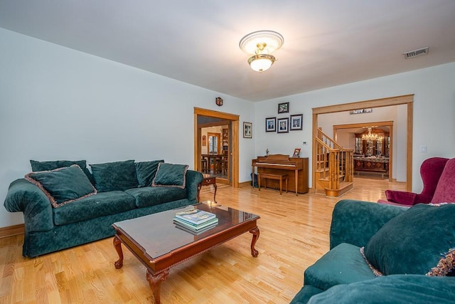 living area with visible vents, wood finished floors, and stairway