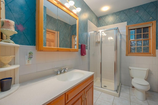 full bath with vanity, tile walls, tile patterned flooring, and a stall shower