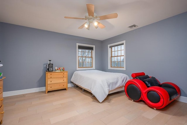 bedroom featuring baseboards, a ceiling fan, light wood-style floors, and visible vents