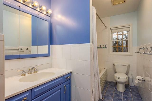 bathroom with visible vents, tile walls, tile patterned floors, vanity, and toilet