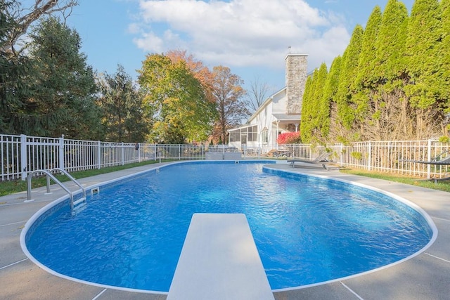 view of swimming pool featuring a fenced in pool, a diving board, fence, and a patio