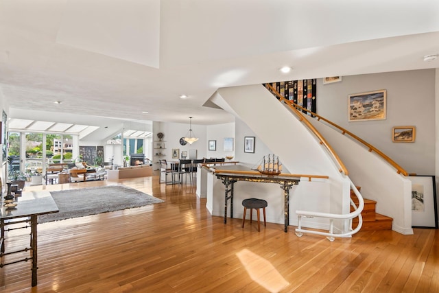 interior space featuring baseboards, recessed lighting, hardwood / wood-style flooring, and stairway