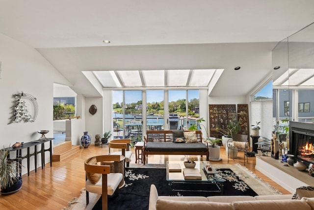 living area with baseboards, a lit fireplace, recessed lighting, and wood finished floors
