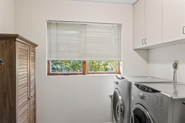 clothes washing area with washing machine and clothes dryer and cabinet space