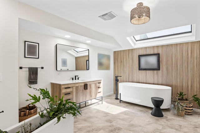 bathroom featuring visible vents, vanity, recessed lighting, a freestanding bath, and a skylight