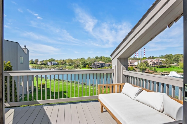 deck featuring a residential view, a yard, a water view, and an outdoor living space