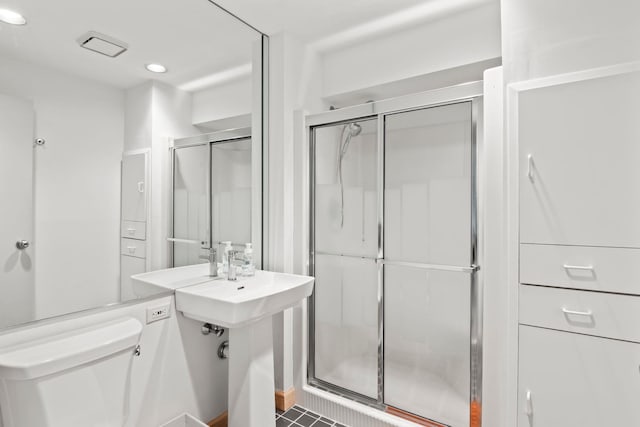 bathroom with recessed lighting, a stall shower, and toilet