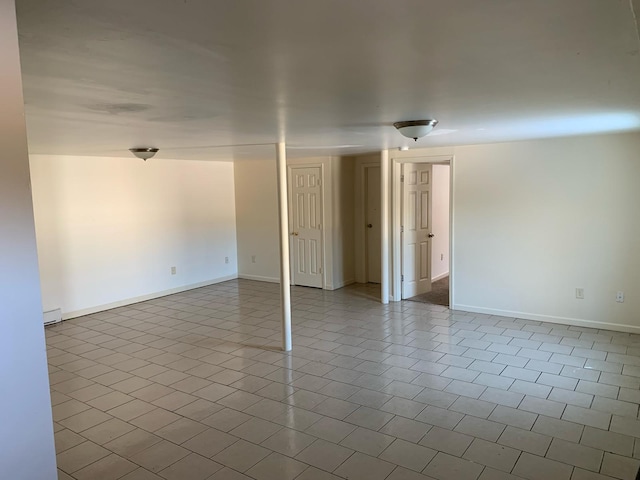 empty room featuring baseboards and tile patterned flooring