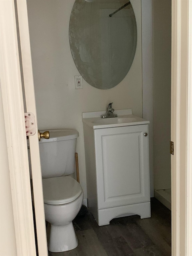 bathroom featuring wood finished floors, toilet, and vanity