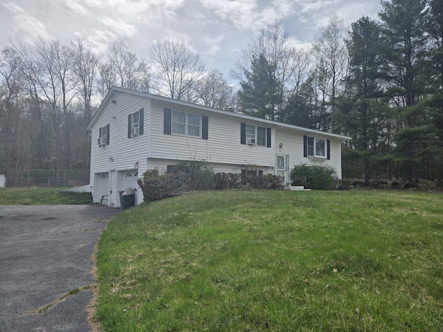 view of front of property with driveway, fence, a front yard, and a garage