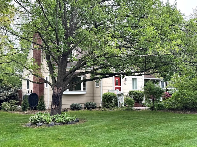541 Peters Blvd, Brightwaters, NY 11718 - view of front of house featuring a front lawn, a chimney, and heating fuel