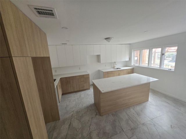 kitchen with marble finish floor, modern cabinets, and visible vents