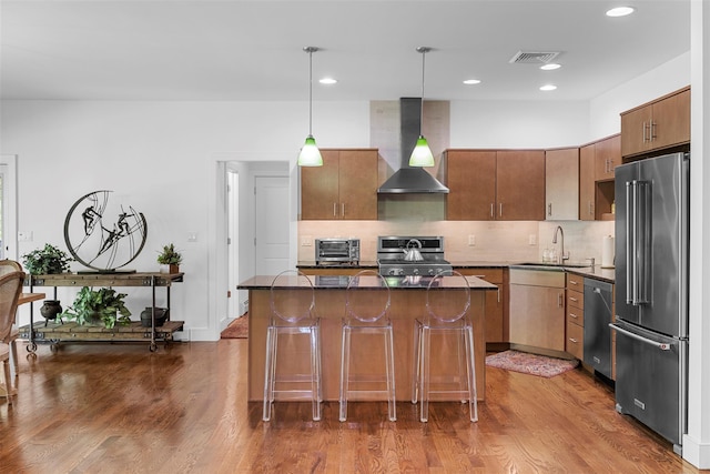 240 Brady Rd, Warwick, NY 10990 - kitchen featuring appliances with stainless steel finishes, wall chimney exhaust hood, a sink, a kitchen island, and a kitchen breakfast bar
