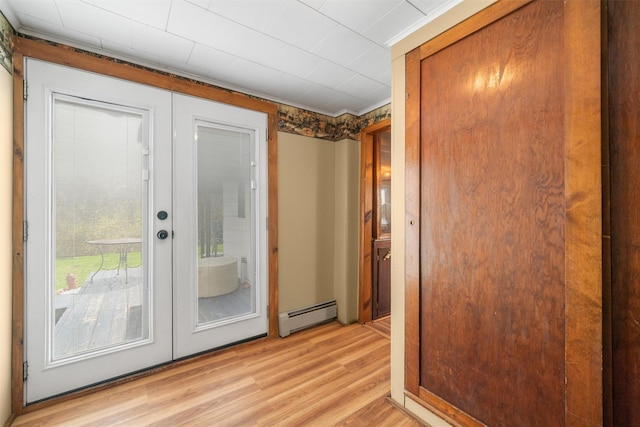 doorway to outside with a baseboard heating unit, light wood finished floors, and french doors