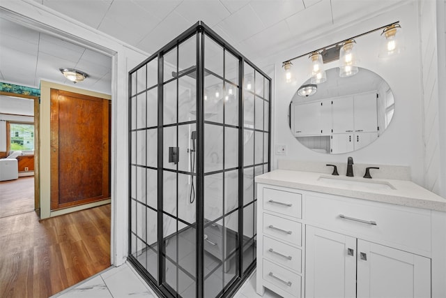 bathroom with a tile shower, marble finish floor, and vanity