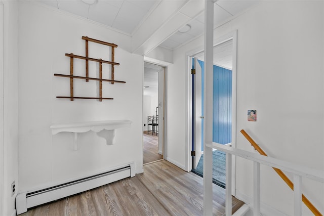 corridor featuring crown molding, an upstairs landing, wood finished floors, and a baseboard heating unit