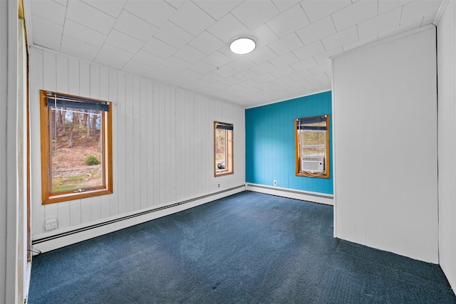 carpeted spare room with a baseboard radiator and wood walls