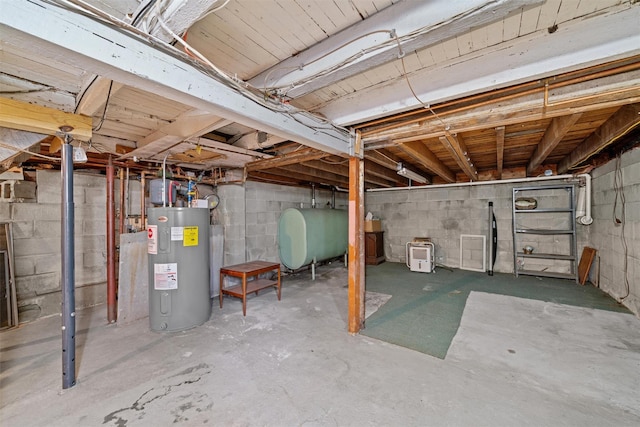unfinished basement with water heater, heating fuel, and concrete block wall