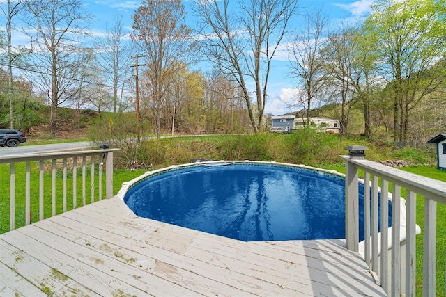 outdoor pool with a yard and a wooden deck