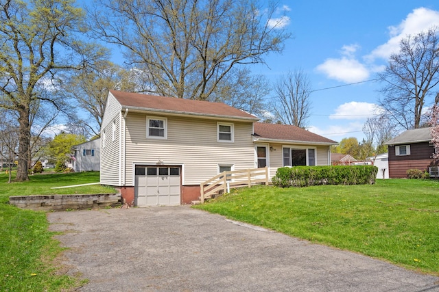 split level home featuring asphalt driveway, a front lawn, and a garage