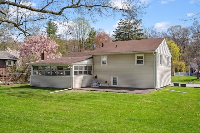 rear view of house featuring a sunroom and a chimney