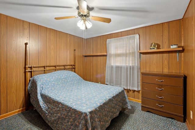bedroom featuring carpet, wood walls, and a ceiling fan
