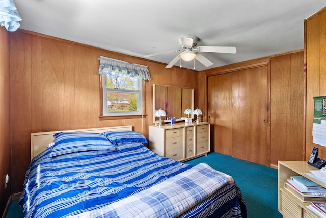bedroom with wood walls, a closet, a ceiling fan, and carpet flooring