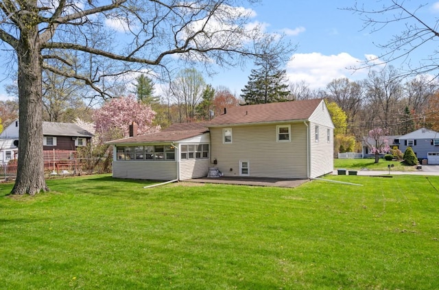back of house featuring a sunroom, a yard, and a patio