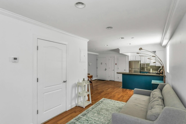 living area featuring wood finished floors, ornamental molding, and recessed lighting