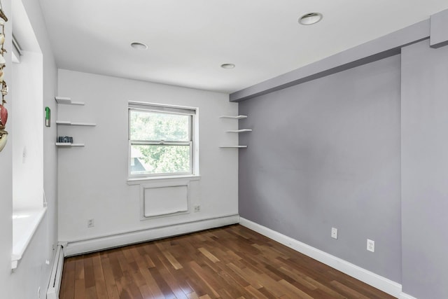 unfurnished room featuring dark wood-type flooring, recessed lighting, a baseboard radiator, baseboard heating, and baseboards